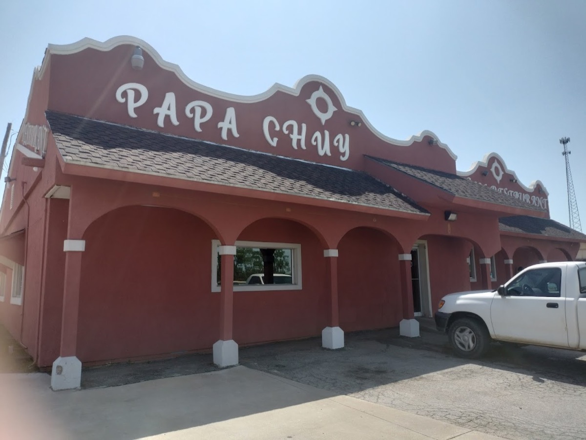 The Papa Chuy restaurant building in Mannford: rose stucco walls, white trim, and arched front porch.